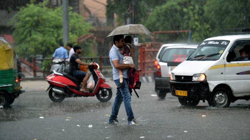 A pedestrian walks across a waterlogged street in the pouring rain on Thursday. (Photo: PTI) A pedestrian walks across a waterlogged street in the pouring rain on Thursday. (Photo: PTI)