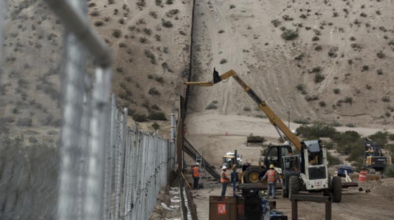 In this file photo, workers continue work raising a taller fence in the Mexico-US border area separating the towns of Anapra, Mexico and Sunland Park. (Photo: AP) In this file photo, workers continue work raising a taller fence in the Mexico-US border area separating the towns of Anapra, Mexico and Sunland Park. (Photo: AP)