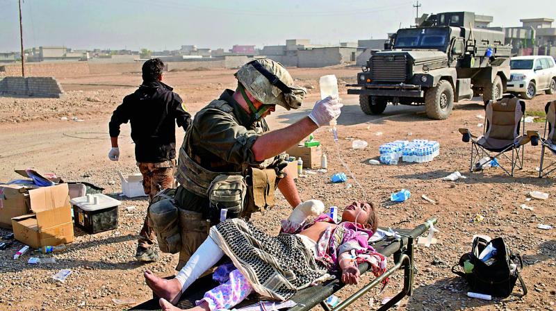 Derek Coleman, centre, a volunteer medic, treats a wounded Iraqi special forces soldier at a field clinic in Gogjali, on the eastern outskirts of Mosul, Iraq. (Photo: AP) Derek Coleman, centre, a volunteer medic, treats a wounded Iraqi special forces soldier at a field clinic in Gogjali, on the eastern outskirts of Mosul, Iraq. (Photo: AP)