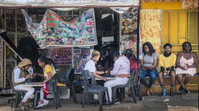 Customers have their nails done near the Baragwanath taxi rank in Soweto, South Africa, Wednesday Sept. 16, 2020. South African president Cyril Ramaphosa is scheduled to address the nation later in the day, as case numbers and death from Covid-19 hit the lowest in months. (AP)