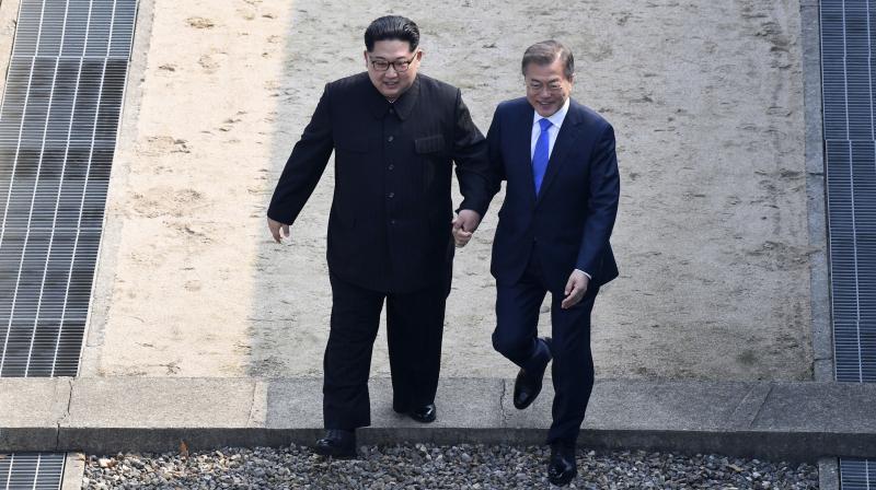 North Korean leader Kim Jong Un, left, and South Korean President Moon Jae-in cross the military demarcation line to the South side at the border village of Panmunjom in the Demilitarized Zone Friday. (Photo: AP) North Korean leader Kim Jong Un, left, and South Korean President Moon Jae-in cross the military demarcation line to the South side at the border village of Panmunjom in the Demilitarized Zone Friday. (Photo: AP)
