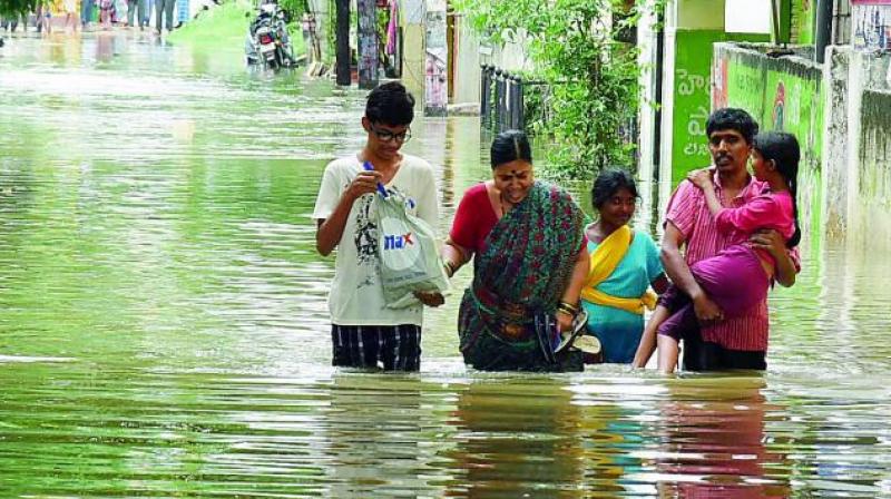 A family walks through the floodwaters to reach a safer place in Hyderabad.