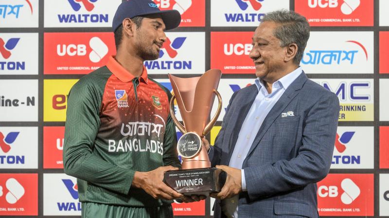 Bangladeshs team captain Mahmudullah (L) receiving the trophy from Bangladesh Cricket Board president Nazmul Hasan Papon after winning the second Twenty20 international of a two-match series against Zimbabwe at the Sher-e-Bangla National Cricket Stadium in Dhaka on March 11, 2020. AFP Photo