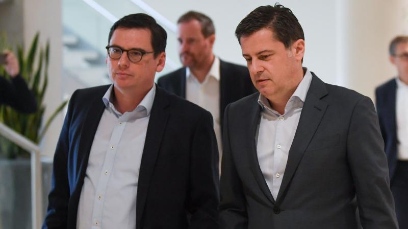 Chief Executive Officer of the DFL Christian Seifert (R) and Finance and Marketting director of SC Freiburg football club Oliver Leki arrive for a general meeting of the German Football League (DFL) in Frankfurt am Main on Tuesday. AFP Photo