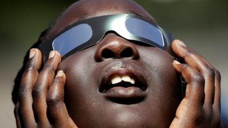 In this photo taken Friday, Aug. 18, 2017, Poureal Long, a fourth grader at Clardy Elementary School in Kansas City, Mo., practices the proper use of eclipse glasses in anticipation of Monday's solar eclipse. Schools around the country preparing for the solar eclipse are reacting in a variety ways, with some using the event for a full day of science lessons and others closing to avoid the crush of crowds expected in their towns. (AP Photo/Charlie Riedel) In this photo taken Friday, Aug. 18, 2017, Poureal Long, a fourth grader at Clardy Elementary School in Kansas City, Mo., practices the proper use of eclipse glasses in anticipation of Monday's solar eclipse. Schools around the country preparing for the solar eclipse are reacting in a variety ways, with some using the event for a full day of science lessons and others closing to avoid the crush of crowds expected in their towns. (AP Photo/Charlie Riedel)