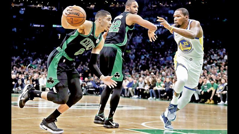 Brooklyn Nets forward Kevin Durant (R) tries to stop Boston Celtics forward Jayson Tatum even as Celtics center Al Horford provides the screen. AP Photo