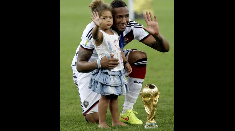 Germanys Jerome Boateng with the World Cup trophy and his daughter following their 1-0 victory over Argentina in the World Cup final in Rio de Janeiro in 2014. AP Photo