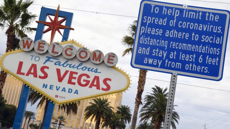 In this file photo, one sign board reads Welcome to Fabulous Las Vegas and the other displays a message about social distancing due to the continuing spread of the coronavirus in Las Vegas, Nevada. NBA officials are studying the possibility of staging the entire playoffs in Las Vegas. AFP Photo