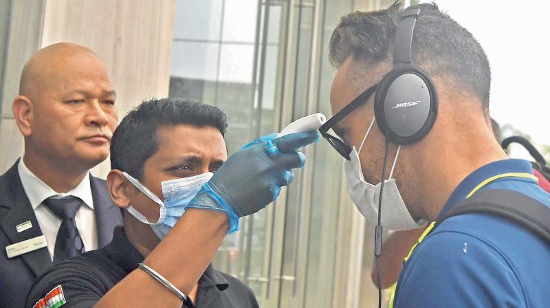 Staff of a Kolkata hotel where the South African cricketers stayed on their way home checking Faf du Plessis temperature. DC File Photo