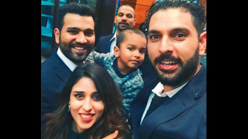 Yuvraj Singh with Rohit Sharma (carrying Shikhar Dhawans son Zoravar) and his wife Ritika in England. DC File Photo