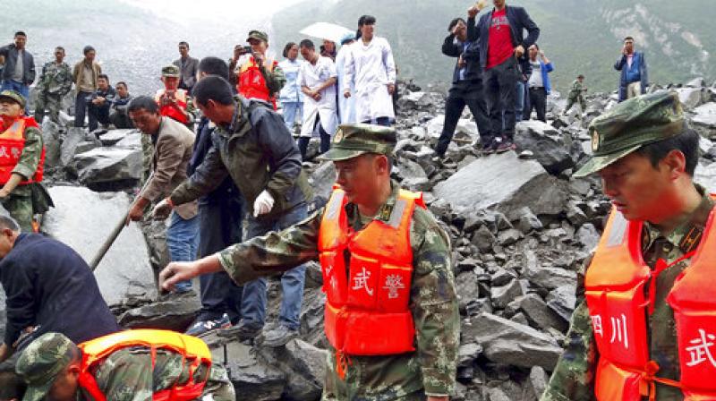 Emergency personnel and local people work at the site of a landslide in Xinmo village in Maoxian County in southwestern China's Sichuan Province on Saturday. (Photo: AP) Emergency personnel and local people work at the site of a landslide in Xinmo village in Maoxian County in southwestern China's Sichuan Province on Saturday. (Photo: AP)