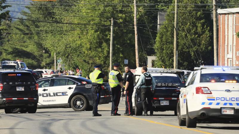 Police officers survey the area of a shooting in Fredericton, New Brunswick, Canada on Friday. (Photo: AP) Police officers survey the area of a shooting in Fredericton, New Brunswick, Canada on Friday. (Photo: AP)