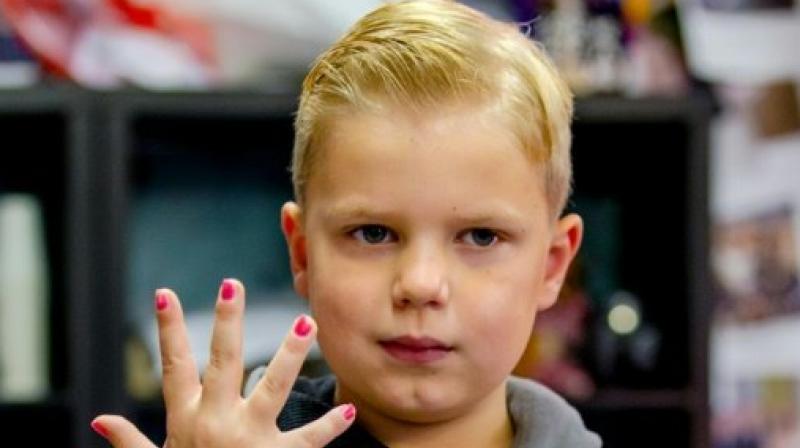 Tijn, a 6-year-old boy, shows his painted nails as he raises money during the Tijn, a 6-year-old boy, shows his painted nails as he raises money during the