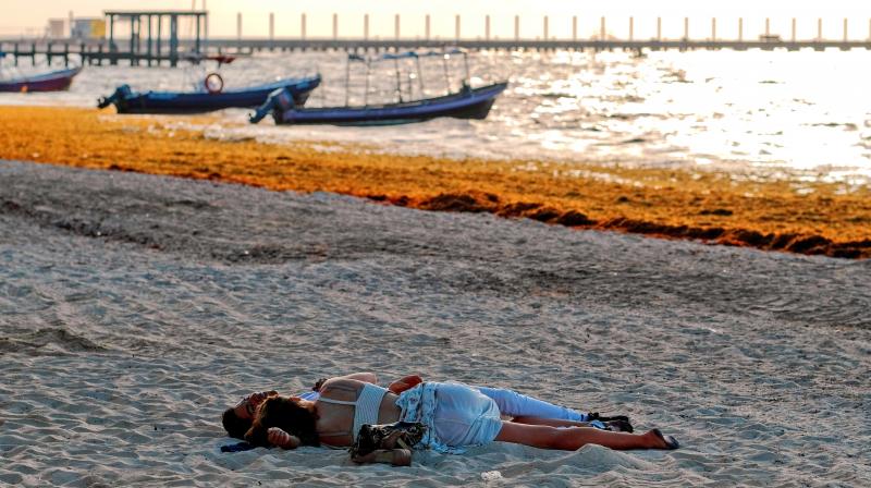 A couple on the beach covered with sargassum in Playa del Carmen, Mexico. (Photo: AP) A couple on the beach covered with sargassum in Playa del Carmen, Mexico. (Photo: AP)