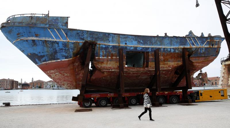 A woman walks past the wreck of the 'Barca Nostra' fishing boat, which sank in the Mediterranean Sea in 2015 with 700 migrants on board, displayed at the 58th Biennale of Arts exhibition in Venice, Italy. (Photo: AP) A woman walks past the wreck of the 'Barca Nostra' fishing boat, which sank in the Mediterranean Sea in 2015 with 700 migrants on board, displayed at the 58th Biennale of Arts exhibition in Venice, Italy. (Photo: AP)