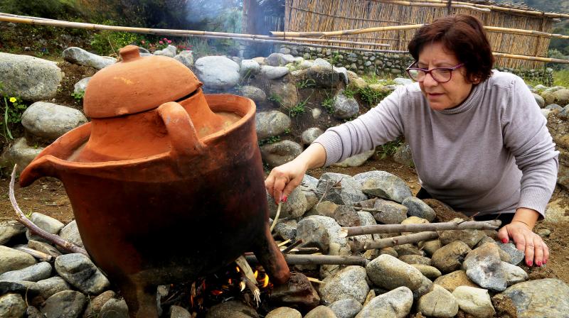 Yiannoula Lazarou tends to a fire boiling perfume inside a second millennium BC distiller discovered in Cyprus at the ancient perfume theme park and museum in Korakou, Cyprus. (Photo: AP) Yiannoula Lazarou tends to a fire boiling perfume inside a second millennium BC distiller discovered in Cyprus at the ancient perfume theme park and museum in Korakou, Cyprus. (Photo: AP)