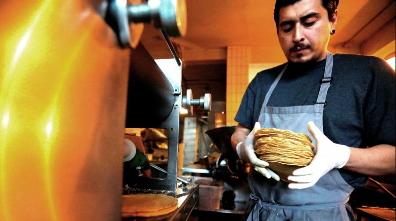 Chef Jesus Saldivar removes freshly made tortillas from the tortilla making machine at El Pujol Mill in the Condesa neighborhood of Mexico City. (Photo: AP) Chef Jesus Saldivar removes freshly made tortillas from the tortilla making machine at El Pujol Mill in the Condesa neighborhood of Mexico City. (Photo: AP)