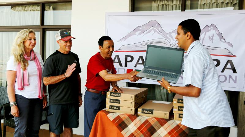 Apa Sherpa (centre) hands over a computer to Chakra Karki, representative of a school from Dhuske, Okhaldhunga district in Kathmandu, Nepal. (Photo: AP) Apa Sherpa (centre) hands over a computer to Chakra Karki, representative of a school from Dhuske, Okhaldhunga district in Kathmandu, Nepal. (Photo: AP)