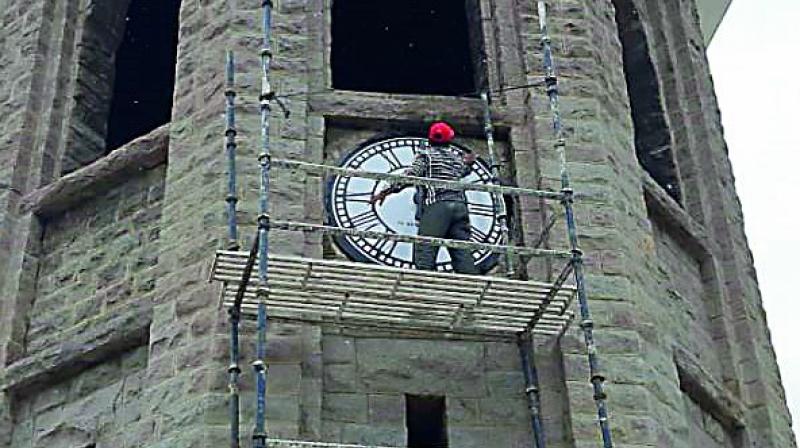 A worker replaces the dial and hands of the clock, which dropped off due to strong winds in May. (Photo: DC) A worker replaces the dial and hands of the clock, which dropped off due to strong winds in May. (Photo: DC)