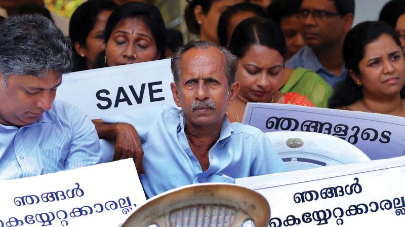 Owners of controversial apartments in Maradu, which the Supreme Court has ordered demolition, stage a dharna in front of Maradu municipality office in Kochi on Tuesday. (Photo: DC) Owners of controversial apartments in Maradu, which the Supreme Court has ordered demolition, stage a dharna in front of Maradu municipality office in Kochi on Tuesday. (Photo: DC)