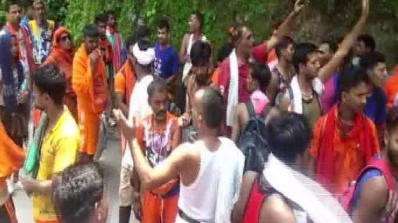 Police resorted to baton charge after the pilgrims blocked the roads and roughed up a car driver and a scooter rider near the Nilkanth Mahadev Temple. (Photo: ANI) Police resorted to baton charge after the pilgrims blocked the roads and roughed up a car driver and a scooter rider near the Nilkanth Mahadev Temple. (Photo: ANI)