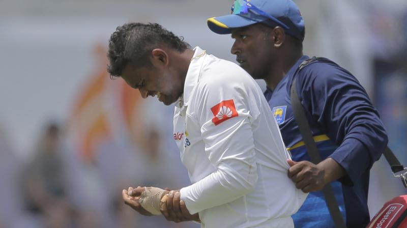 Asela Gunaratne grimaces in pain after being injured during the first day's play of the first test cricket match between India and Sri Lanka in Galle. (Photo: AP)) Asela Gunaratne grimaces in pain after being injured during the first day's play of the first test cricket match between India and Sri Lanka in Galle. (Photo: AP))