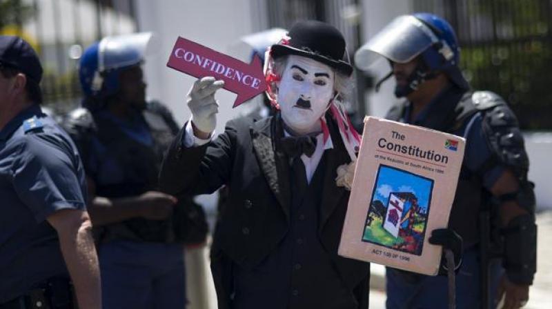 A protester dressed up as Charlie Chaplin and holding a picture of the South African constitution demonstrates outside the South African parliament before a no-confidence debate against President Jacob Zuma in Cape Town on November 10, 2016. (Photo: AFP) A protester dressed up as Charlie Chaplin and holding a picture of the South African constitution demonstrates outside the South African parliament before a no-confidence debate against President Jacob Zuma in Cape Town on November 10, 2016. (Photo: AFP)