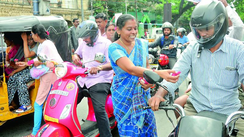 Agitating RTC employees distribute flowers to motorists, seeking their support to the ongoing strike, at Vidyanagar signal in Hyderabad on Sunday. (Photo: Deepak Deshpande) Agitating RTC employees distribute flowers to motorists, seeking their support to the ongoing strike, at Vidyanagar signal in Hyderabad on Sunday. (Photo: Deepak Deshpande)