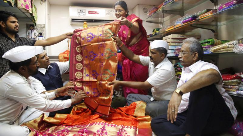 Mumbai dabbawalla look at traditional attire to send as gifts for the wedding of Britain's Prince Harry and Meghan Markle on Thursda. (Photo: AP) Mumbai dabbawalla look at traditional attire to send as gifts for the wedding of Britain's Prince Harry and Meghan Markle on Thursda. (Photo: AP)