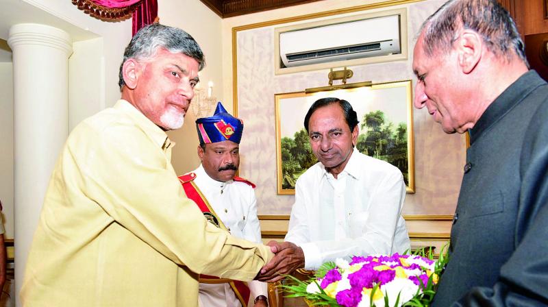 Telangana Chief Minister K. Chandrasekhar Rao with his Andhra Pradesh counterpart Chandrababu Naidu and Governor E.S.L Narasimhan. Telangana Chief Minister K. Chandrasekhar Rao with his Andhra Pradesh counterpart Chandrababu Naidu and Governor E.S.L Narasimhan.