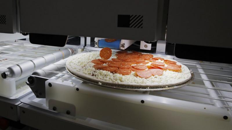 Picnics pizza-making robot makes a pizza at a food vendors booth during the CES tech show, Wednesday, Jan. 8, 2020, in Las Vegas. (AP Photo/John Locher)