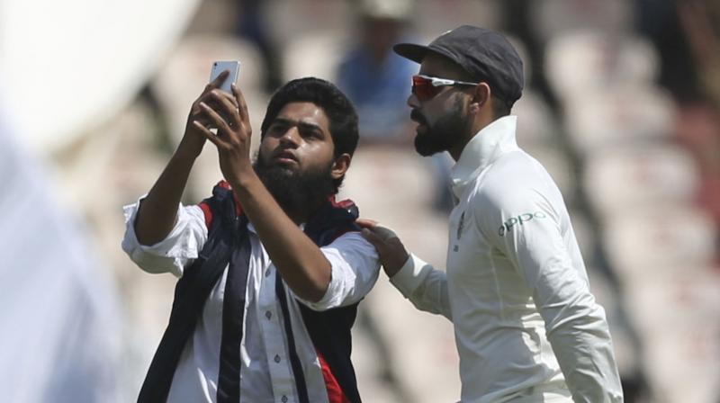 A similar incident had happened during the first Test in Rajkot also when Kohli was surrounded by two pitch invaders trying to take selfies. (Photo: AP) A similar incident had happened during the first Test in Rajkot also when Kohli was surrounded by two pitch invaders trying to take selfies. (Photo: AP)