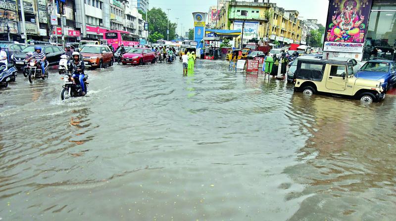 The road at Ranigunj comes under water after a spell of rain on Monday. With many other roads inundated, dozens of municipal workers and police tried to clear drains. (Photo: P. Surender REddy) The road at Ranigunj comes under water after a spell of rain on Monday. With many other roads inundated, dozens of municipal workers and police tried to clear drains. (Photo: P. Surender REddy)