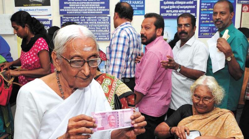 An elderly woman shows the newly-introduced Rs 2000 currency note at SBT main branch in Thiruvananthapuram. An elderly woman shows the newly-introduced Rs 2000 currency note at SBT main branch in Thiruvananthapuram.