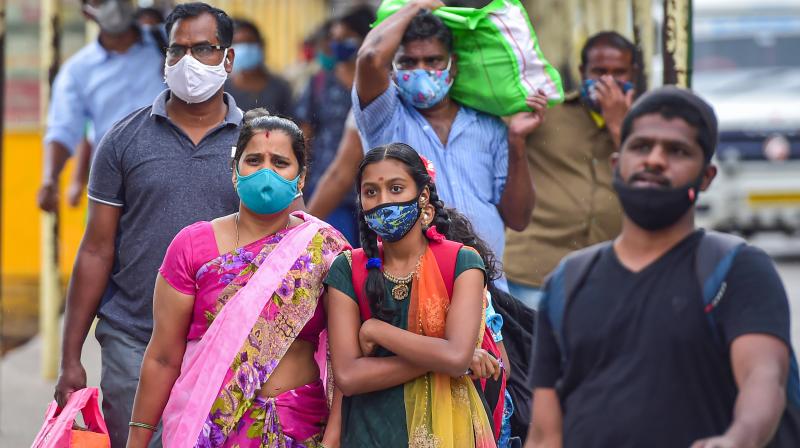 Passengers wear face masks for prevention against COVID-19, at Sangolli Rayanna railway station in Bengaluru. (PTI)