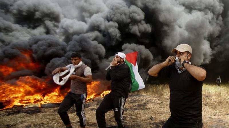 Demonstrators torched large piles of tires, engulfing the area in black smoke meant to shield them from Israeli snipers. (Photo: AP) Demonstrators torched large piles of tires, engulfing the area in black smoke meant to shield them from Israeli snipers. (Photo: AP)