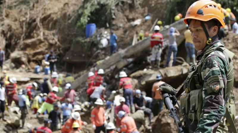 A Filipino trooper keeps guard as search operations continue at the site where victims are believed to have been buried by a landslide triggered by Typhoon Mangkhut lashed across Itogon, Benguet province, northern Philippines. (Photo: AP) A Filipino trooper keeps guard as search operations continue at the site where victims are believed to have been buried by a landslide triggered by Typhoon Mangkhut lashed across Itogon, Benguet province, northern Philippines. (Photo: AP)