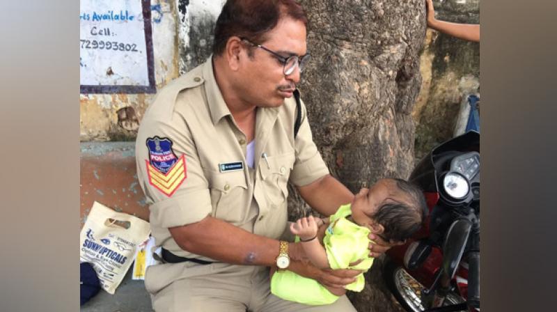 'Head Constable Officer Mujeeb-ur-Rehman (of Moosapet PS) who was on duty for conducting SCTPC exam in Boys Junior College, Mahbubnagar, trying to console a crying baby, whose mother was writing exam inside the hall,' Rajeswari wrote alongside the image. (Photo: ANI) 'Head Constable Officer Mujeeb-ur-Rehman (of Moosapet PS) who was on duty for conducting SCTPC exam in Boys Junior College, Mahbubnagar, trying to console a crying baby, whose mother was writing exam inside the hall,' Rajeswari wrote alongside the image. (Photo: ANI)