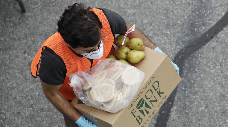 A volunteer readies to load food onto a car at a food distribution center. (AP) A volunteer readies to load food onto a car at a food distribution center. (AP)