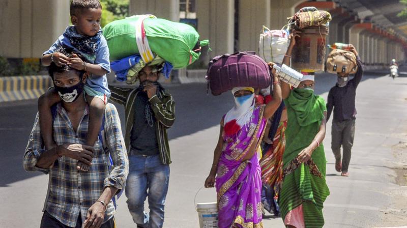 Nagpur: Migrant workers from Balaghat (MP) carry their belongings as they walk towards their native places, during the nationwide lockdown to curb the spread of coronavirus, in Nagpur. PTI Photo