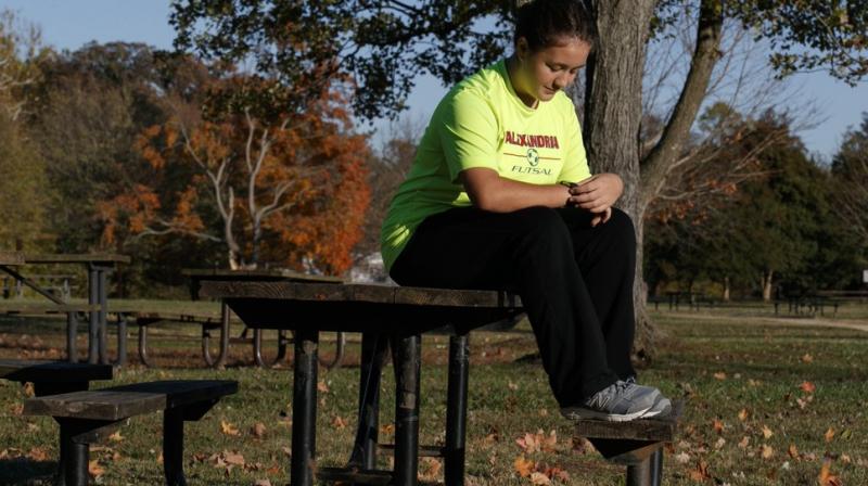 Grace Brown, 14, adjusts her fitness tracker at the park where she does her jogging workouts for her \online PE\ class, in Alexandria, Va., Friday, Nov. 1, 2019. Brown chose to take \online PE,\ utilizing a fitness tracker, so that she could take a piano lab as an extra elective. (AP Photo/Jacquelyn Martin)