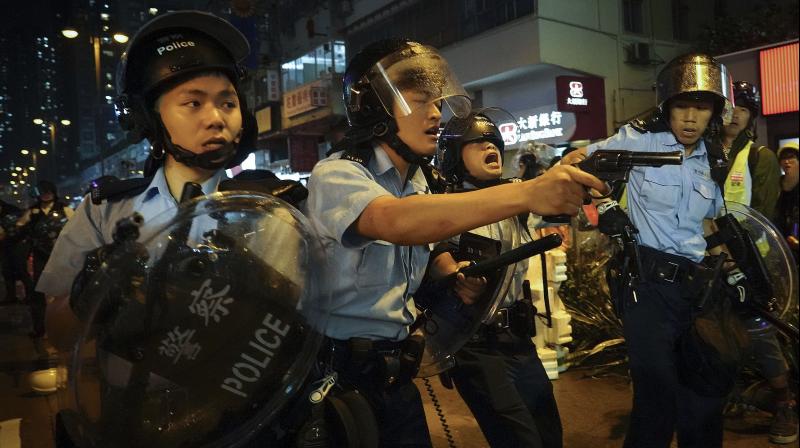 Officers pulled their guns after a group of remaining protesters chased them down a street with sticks and rods, calling them 'gangsters.' The officers held up their shields to defend themselves as they retreated. (Photo: AP) Officers pulled their guns after a group of remaining protesters chased them down a street with sticks and rods, calling them 'gangsters.' The officers held up their shields to defend themselves as they retreated. (Photo: AP)