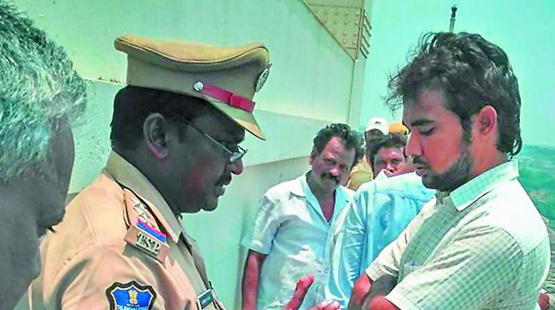 A cop tries to cool frayed tempers at Nagarjunasagar dam on Monday. (Photo: Deccan chronicle) A cop tries to cool frayed tempers at Nagarjunasagar dam on Monday. (Photo: Deccan chronicle)