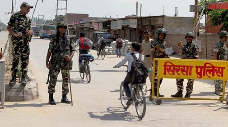 Security forces stand guard at Satnam Chowk, the main entrance to the Dera Sacha Sauda headquarters, in Sirsa district of Haryana. (Photo: PTI) Security forces stand guard at Satnam Chowk, the main entrance to the Dera Sacha Sauda headquarters, in Sirsa district of Haryana. (Photo: PTI)