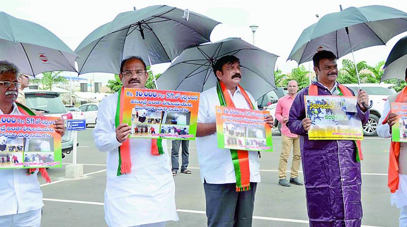 BJP legislators stand in front of the AP Assembly with umbrellas and wearing a raincoat, on Thursday. (Photo: DC) BJP legislators stand in front of the AP Assembly with umbrellas and wearing a raincoat, on Thursday. (Photo: DC)