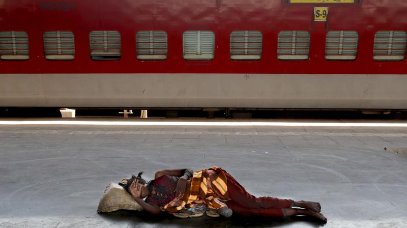 A homeless woman sleeps on a deserted platform of the Lokmanya Tilak train terminus in Mumbai. (File photo: AP)