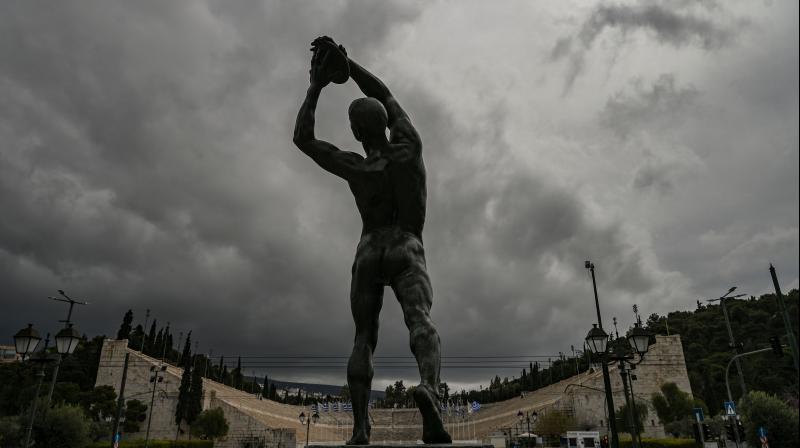 A statue of a discus thrower stands opposite Athens Panathenaic stadium or Kalimarmaro, where the first modern Olympic Games began, in Athens, one day after the historic decision to postpone the 2020 Tokyo Olympic Games. Japan on March 25 started the unprecedented task of reorganising the Tokyo Olympics after the historic decision to postpone the worlds biggest sporting event due to the COVID-19 coronavirus pandemic that has locked down one third of the planet. (AFP)