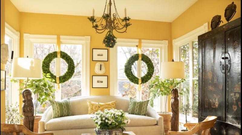 This photo shows a room design by Josh Hildreth. This Washington, D.C., sunroom feels bright even on winter afternoons, thanks to windows that dont have any draperies, a light-colored rug and citrus trees that add a fresh, bright scent to the space.AP