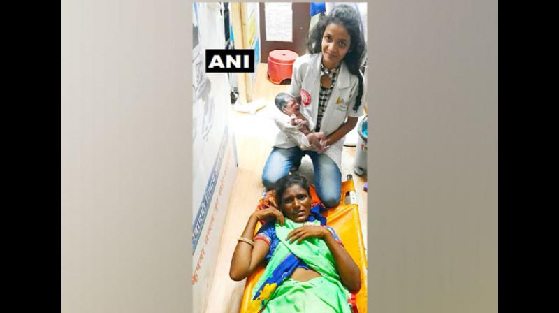 Pooja Chauhan who gave birth at Thane Railway station, with baby held by a clinic staff. (Photo: ANI) Pooja Chauhan who gave birth at Thane Railway station, with baby held by a clinic staff. (Photo: ANI)