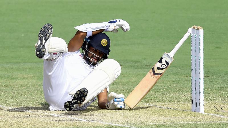 Karunaratne slumped to the ground, dropping his bat as Australian players ran to assist. (Photo: AFP) Karunaratne slumped to the ground, dropping his bat as Australian players ran to assist. (Photo: AFP)